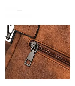 Detail of smooth metal zipper and lychee pattern leather on brown shoulder bag