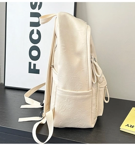 Vista lateral de la mochila de cuero sintético suave blanco roto con correas ajustables
