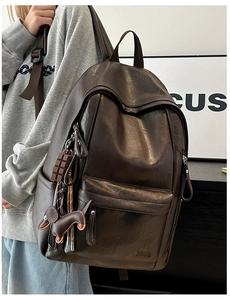 Mochila grande de cuero PU marrón oscuro con lindos dijes mostrada en un modelo