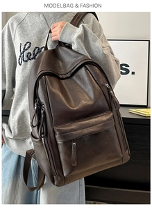 Detalle de la mochila de cuero PU marrón oscuro con bolsillo frontal con cremallera y logo