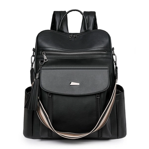 Detail of large black PU leather backpack with striped shoulder strap and tassel