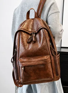 Detalle de la mochila de cuero sintético marrón oscuro con logo grabado y cremalleras