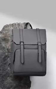 Detail of grey industrial backpack with matte leather texture and metal buckle straps