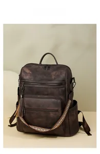 Close-up of vintage brown leather backpack with multiple pockets and colorful woven strap