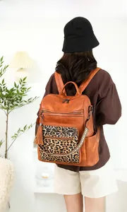 Rear view of a model wearing the vintage leopard print backpack with tassel detail