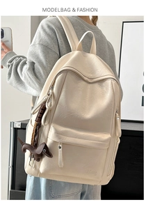 Detalle de la mochila de cuero suave blanco crema con textura granulada y colgante