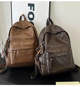 Detailed view of vintage soft leather backpacks in brown and dark coffee with creative charms