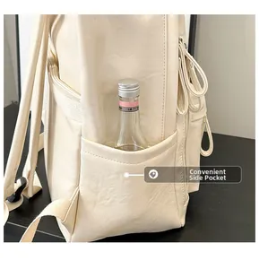 Detalle del bolsillo lateral de una mochila de cuero sintético crema con botella