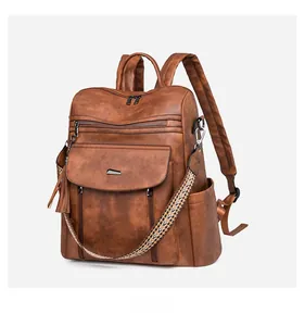Detail of brown PU leather backpack with vintage texture and colorful woven shoulder strap