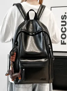 Detalle de la mochila de cuero PU negro suave con colgantes y logotipo Hoog sutil