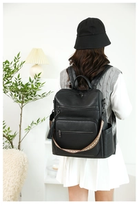 Black leather backpack featuring vintage geometric patterns and stylish tassel details