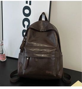 Detailed close-up of dark brown soft synthetic leather backpack with front zipper pocket