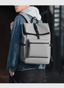 Vue latérale d'un sac à dos minimaliste gris clair porté par un mannequin en milieu urbain