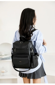 Vista posterior de una modelo con un conjunto de mochilas negras de cuero sintético