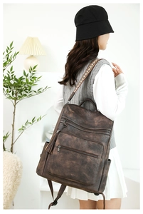 Detail of vintage brown leather backpack with colorful ethnic geometric woven strap