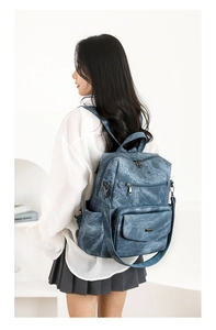 Conjunto de mochila azul retro de gran capacidad en modelo en un estudio blanco