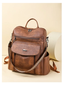 Detail view of large brown PU leather backpack with vintage ethnic style woven strap