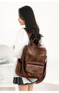 Vista lateral de un conjunto de mochila vintage marrón oscuro en una modelo
