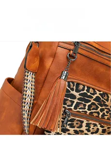 Detail of vintage brown leather backpack with leopard print pockets and tassel zipper