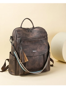Close-up of vintage brown PU leather backpack with striped strap and tassel detail