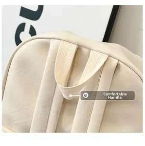 Detalle de la textura de cuero PU suave y asa de tejido reforzado en la mochila crema