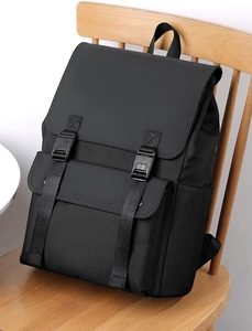 Detailed side view of a black waterproof business backpack with side pocket on a wooden chair