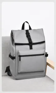 Détail du sac à dos étanche gris avec fermeture à boucle sur un canapé en tissu