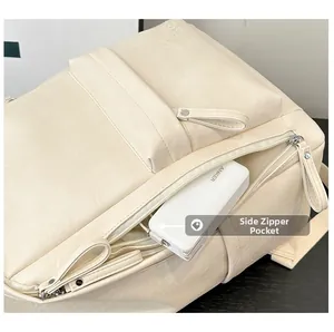 Detalle del bolsillo lateral con cremallera en una mochila de cuero beige con cargador