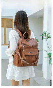 Brown PU leather backpack with vintage ethnic woven strap and tassel detail on model