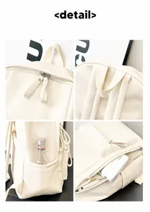 Detalle de la mochila de cuero blanco crema con cremalleras, asa y bolsillo lateral
