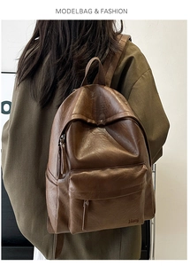 Detail view of large dark brown leather backpack on model with soft texture and Hoog logo