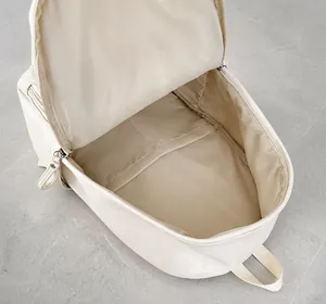 Vista superior de los amplios compartimentos internos de la mochila de cuero beige