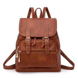 Detailed view of brown PU leather backpack featuring lychee texture and buckle flap