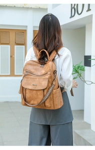 Brown PU leather backpack detail with tassels and bohemian woven shoulder strap detail