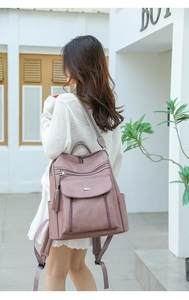 Detailed back view of a mauve PU leather backpack with a colorful woven shoulder strap