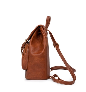 Side view of vintage brown PU leather backpack with contrast stitching and side pockets