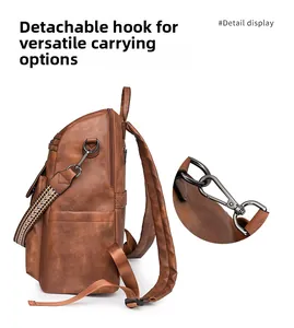Detail view of the detachable metal hook and vintage brown PU leather texture on the backpack