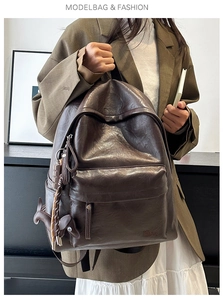 Detail of dark brown leather backpack with horse charm and brand logo in a lifestyle setting