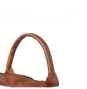 Close-up of the round brown PU leather handle showing fine stitching and smooth texture