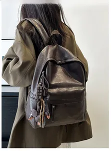 Detail of soft dark brown leather backpack with creative charms and spacious compartments