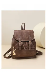 Detailed view of a vintage brown PU leather backpack with flap closure and heart charm