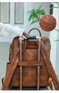 Brown PU leather backpack with a luggage strap for attaching to suitcase handles