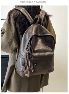 Detail of dark brown leather backpack with chocolate and puppy charms in retro style
