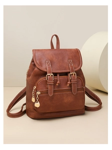 Close-up of vintage brown PU leather backpack with buckle straps and a gold heart zipper