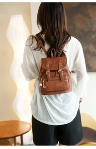 Close-up of caramel brown PU leather backpack with gold heart zipper and buckle detail