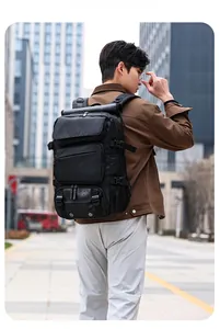 Black multi-pocket travel backpack shown on person with city background view