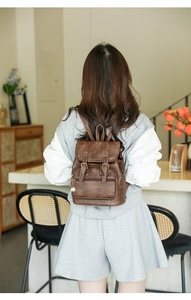 Brown vintage PU leather mini backpack shown on model back in a bright indoor setting