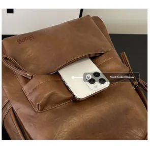 Close-up of brown soft leather backpack front pocket showing large smartphone storage