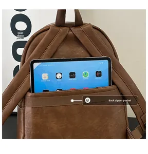 Close-up of brown PU leather backpack rear showing padded straps and hidden tablet pocket