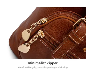 Detail of vintage brown leather bag with dual golden zippers and white contrast stitching